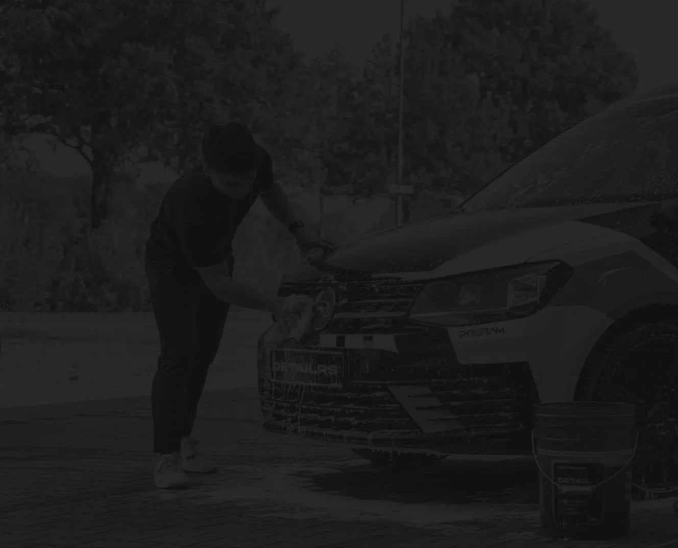 Detailrs autoshampoo foampasta man wast auto voorzijde met emmer buiten