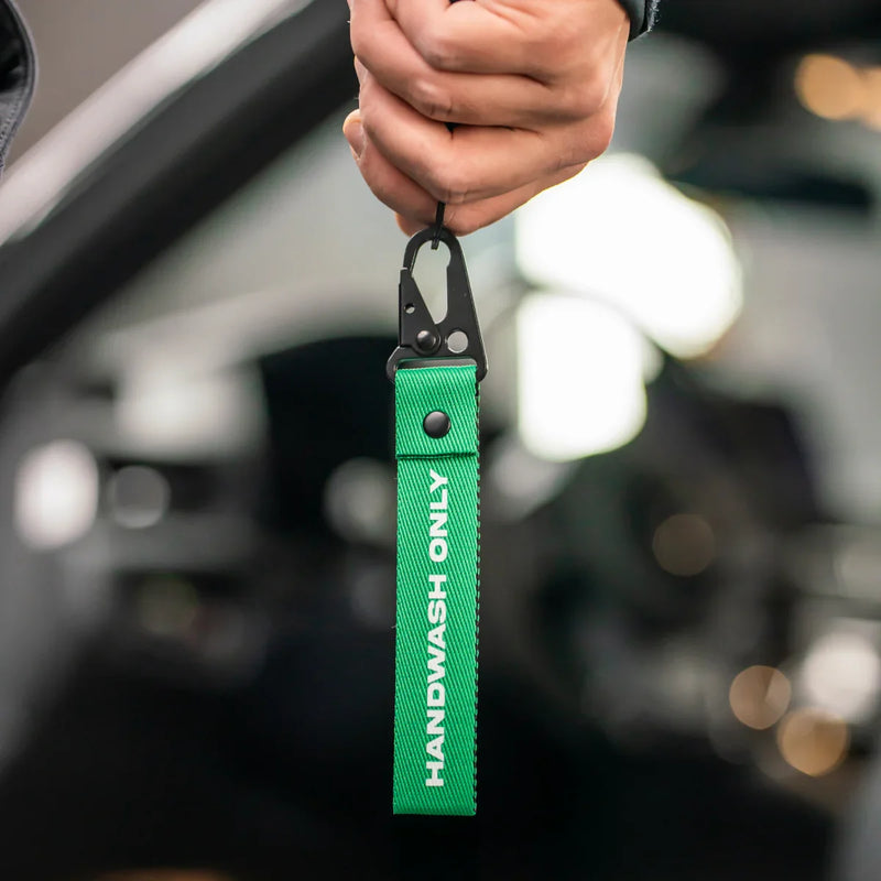 Detailrs sleutelhanger handwash only groen met zwarte clip in hand vastgehouden